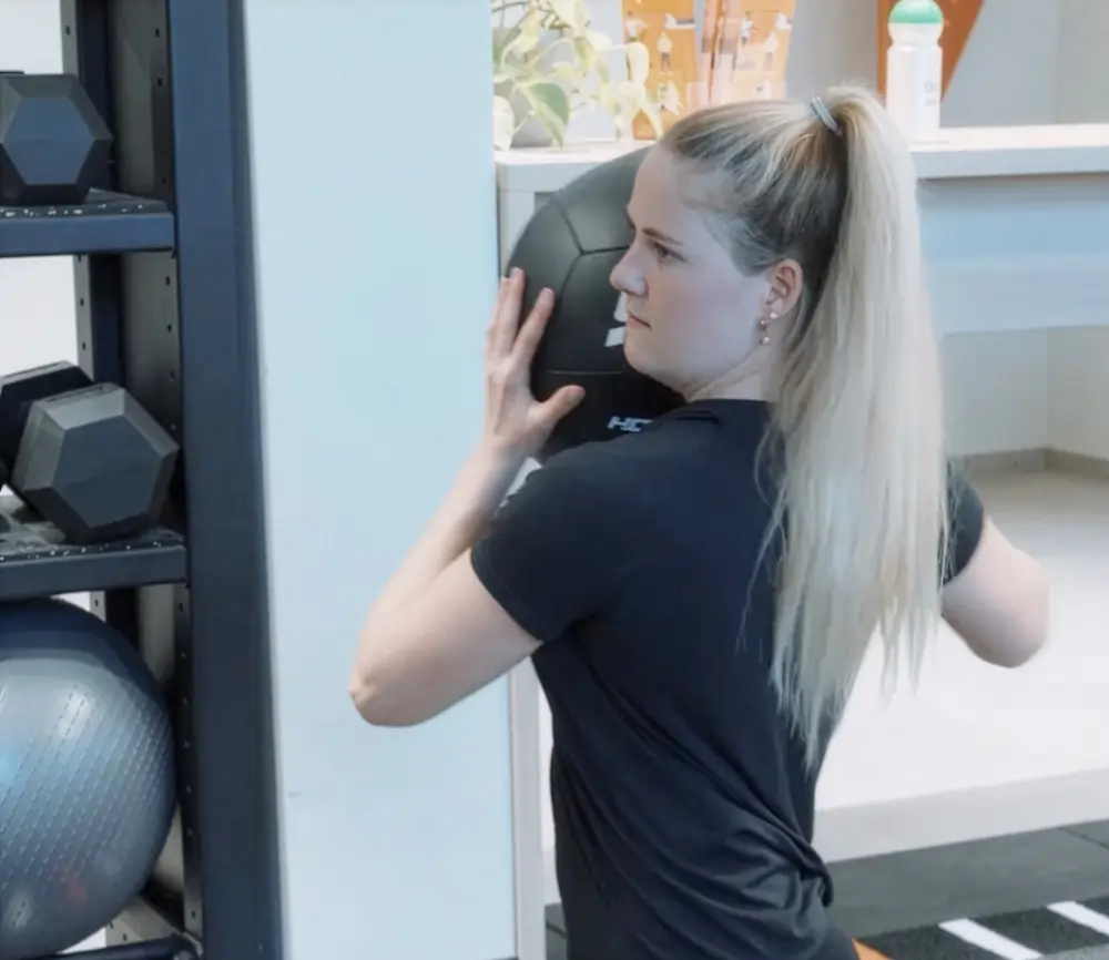 Frau trainiert mit Medizinball.