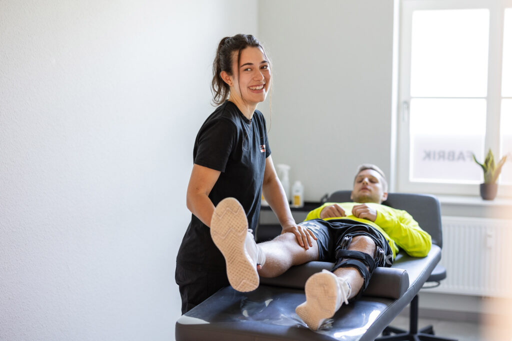Physiotherapeutin behandelt Menschen auf der Liege