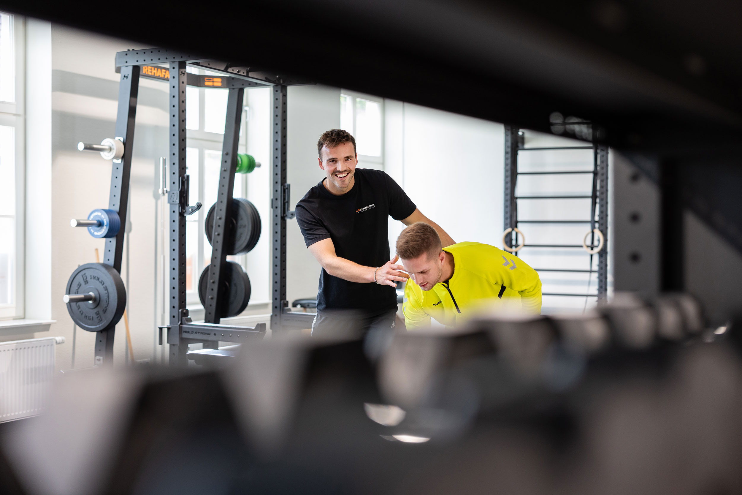 Employee assists clients with rehabilitation exercises at REHAFABRIK