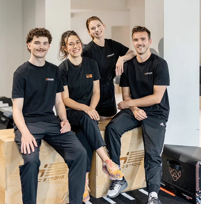 Vier Personen in Sportkleidung posieren.